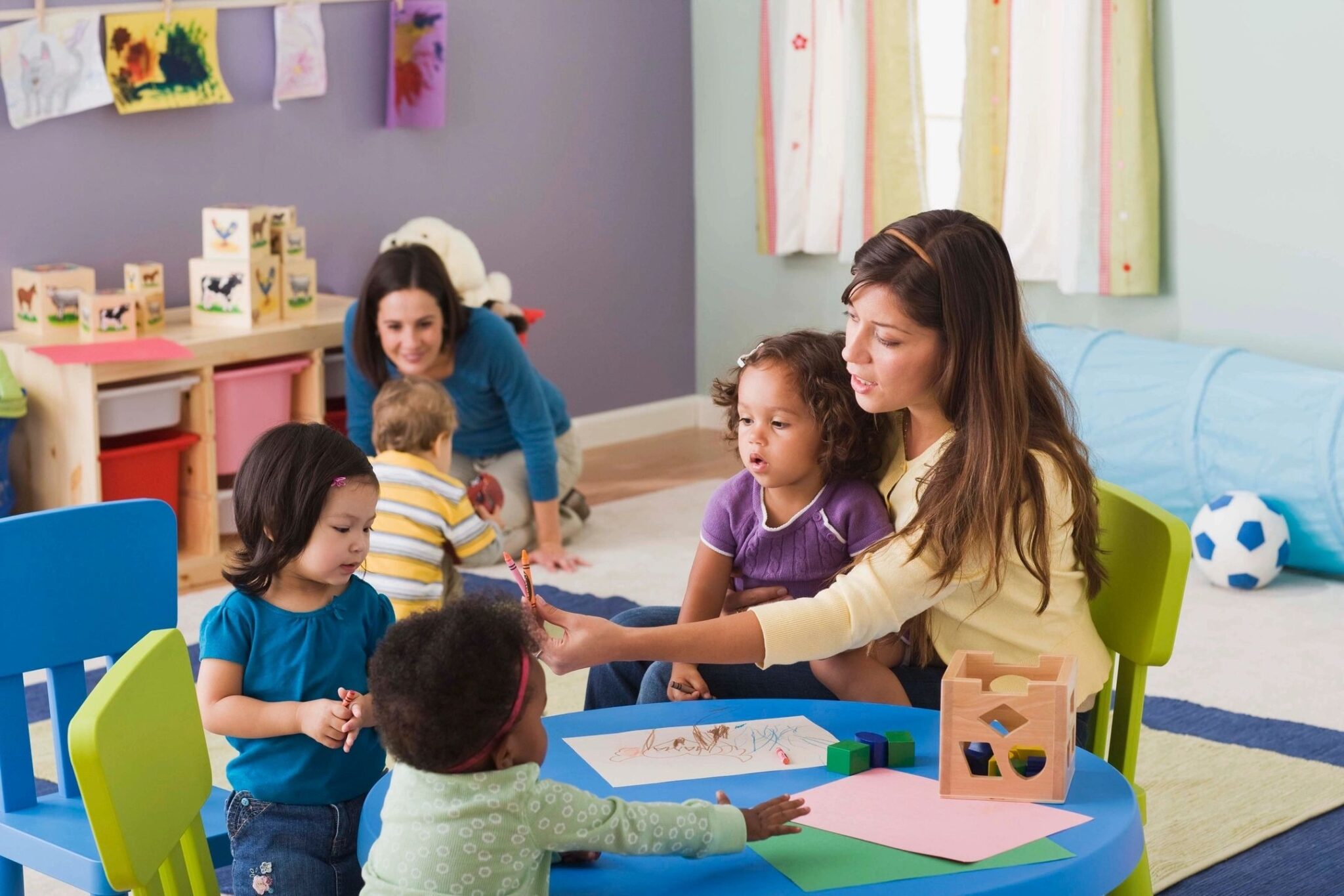 A woman is helping children with crafts.