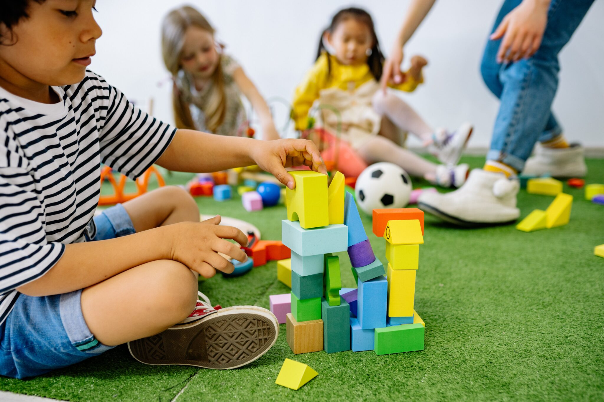 A group of children playing with blocks on the floor.